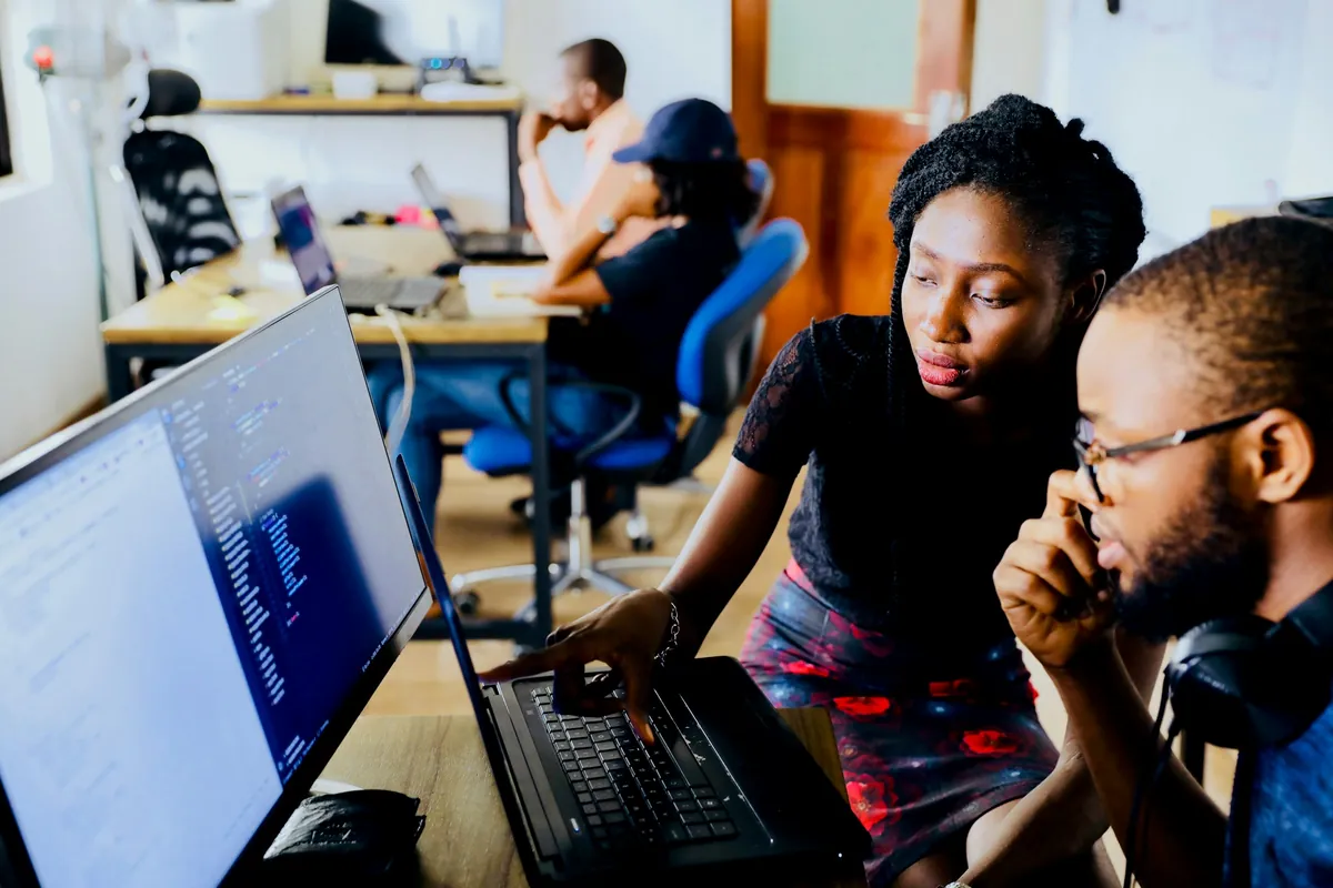 Two developers reviewing code together at a workstation