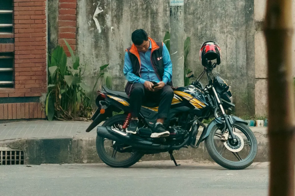 Motorbike rider checking the next job on his phone