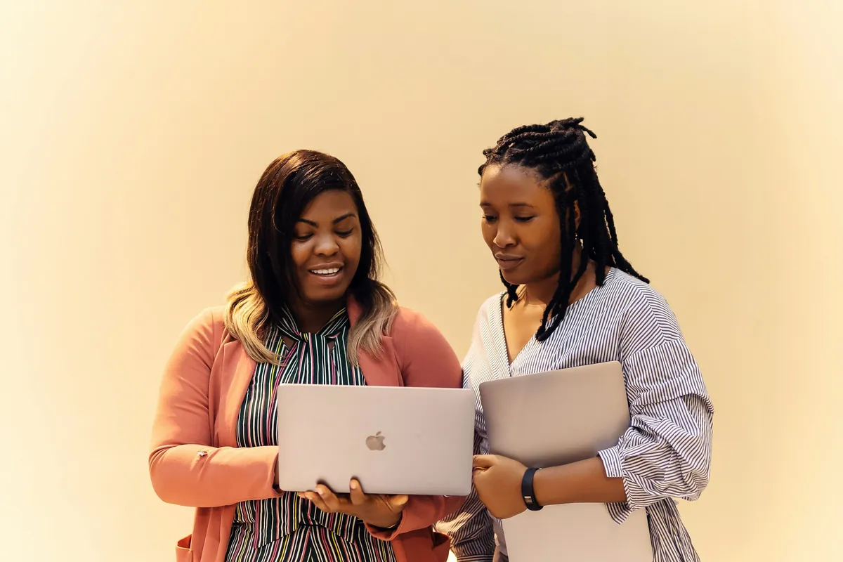 Two colleagues reviewing a laptop together