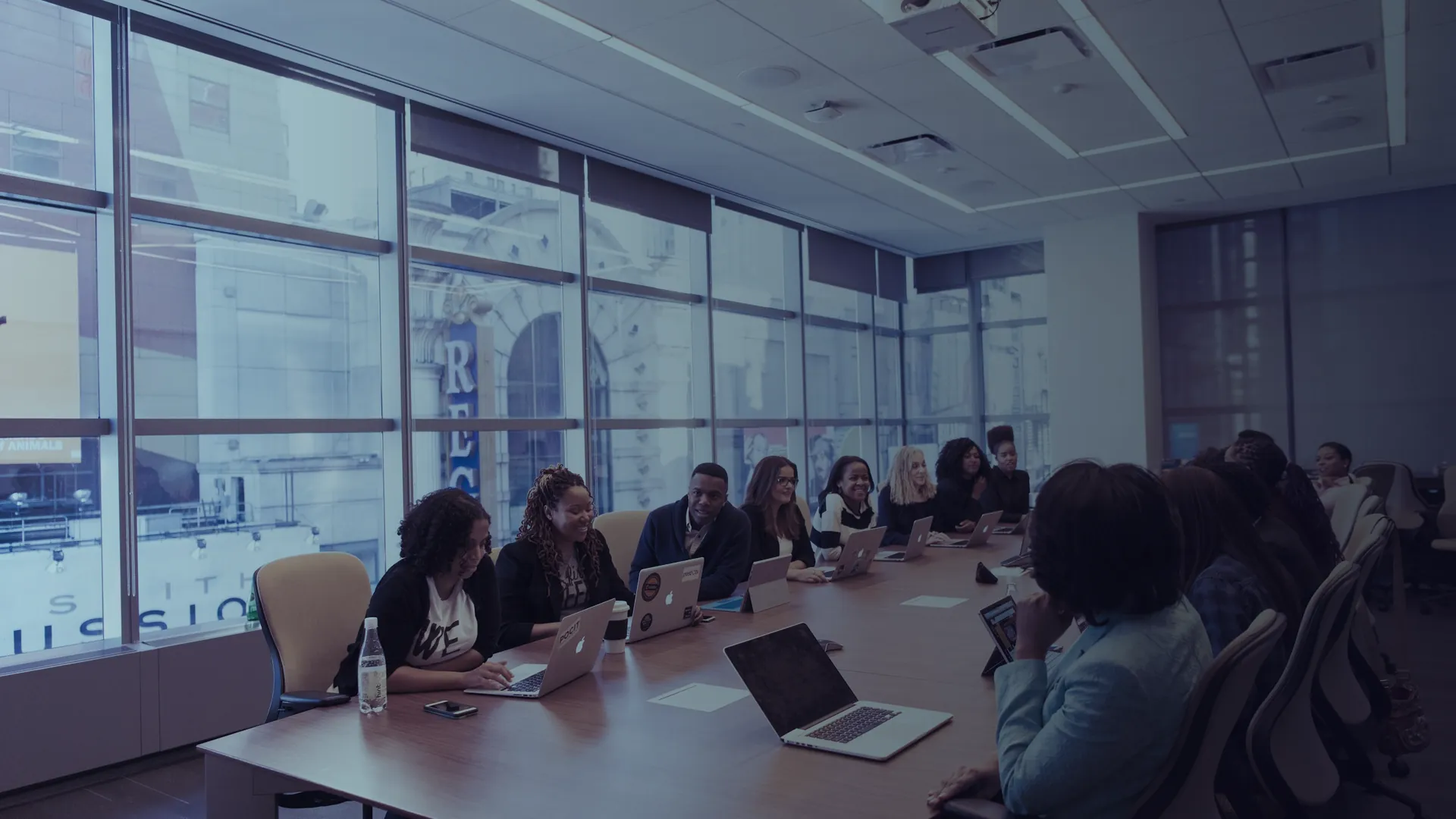 Team seated around a boardroom table with laptops