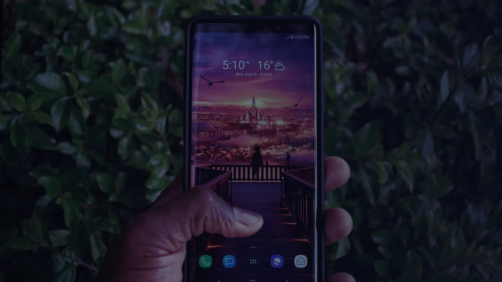 Hand holding a smartphone outdoors